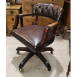 A period style office swivel armchair, tub shaped and upholstered in brown hide