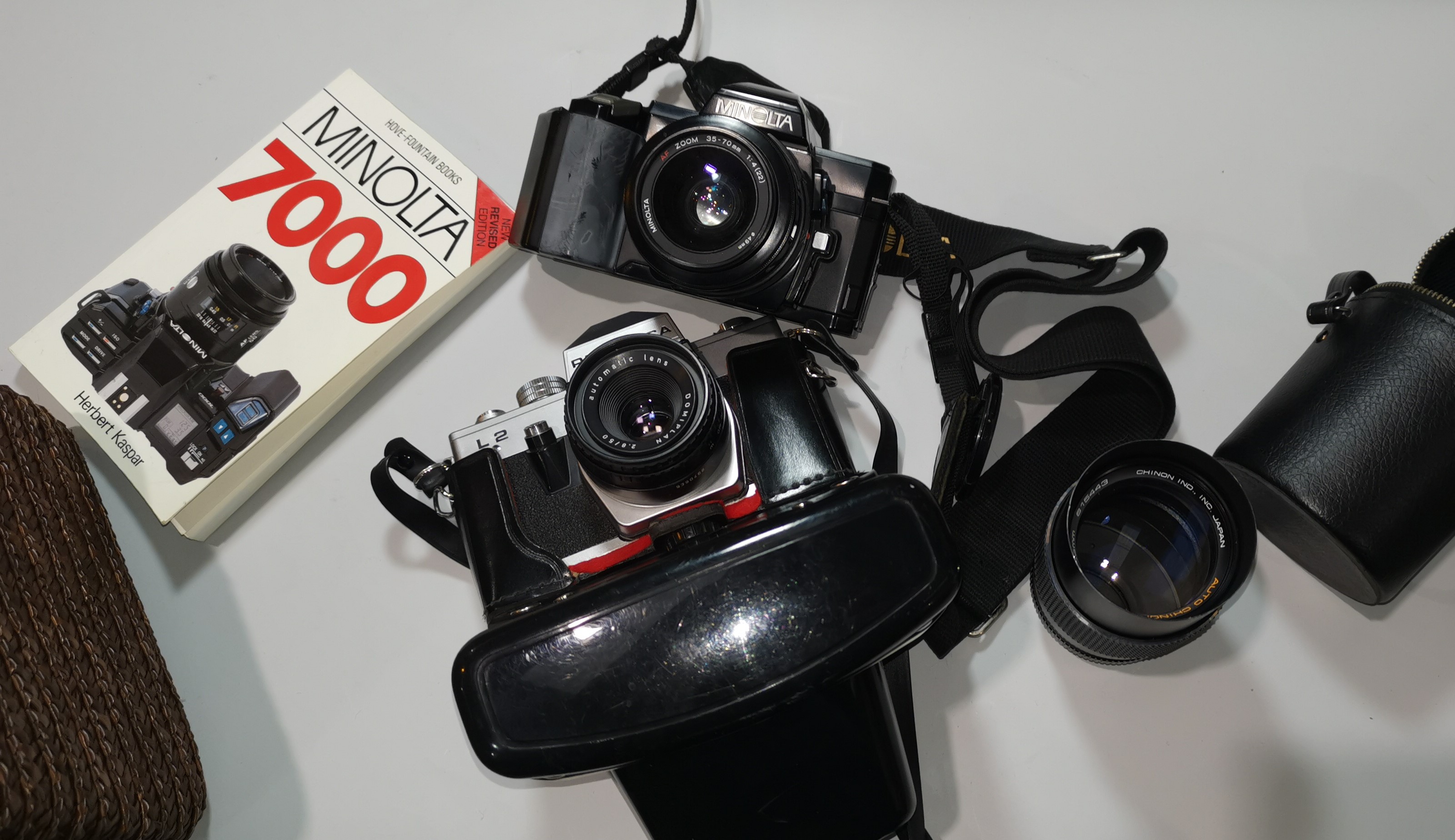 A Minolta 7000 SLR camera with 35-70 mm lens; a Chinon 135 mm lens; a Pentacon camera; etc.