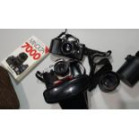 A Minolta 7000 SLR camera with 35-70 mm lens; a Chinon 135 mm lens; a Pentacon camera; etc.