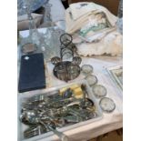 A glass dressing table set; a selection of silver plated cutlery; a selection of table linen;