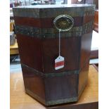A mahogany octagonal cellarette with brass straps and ring patera handles. 16 1/2' high