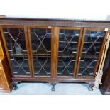 An early 20th century mahogany bookcase enclosed by four astragal glazed doors on cabriole ball