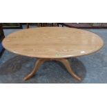 An Ercol light wood oval low table on quadripartite support. 48' wide