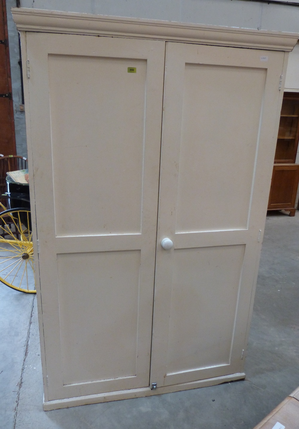 A painted pine wardrobe enclosed by a pair of panel doors. 45' wide