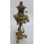 A Victorian brass oillamp on scrolled wrought tripartite support. Converted for electricity 17½'