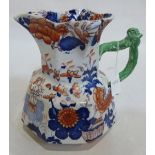 A Masons Ironstone jug decorated in imari palette. 9½' high. Cracked