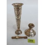 A silver repousse decorated bud vase (loaded); a silver squat candlestick and a plated lady's