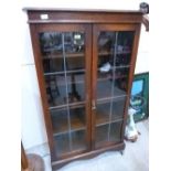 A 1930s oak bookcase enclosed by a pair of leaded glazed doors. 32' wide