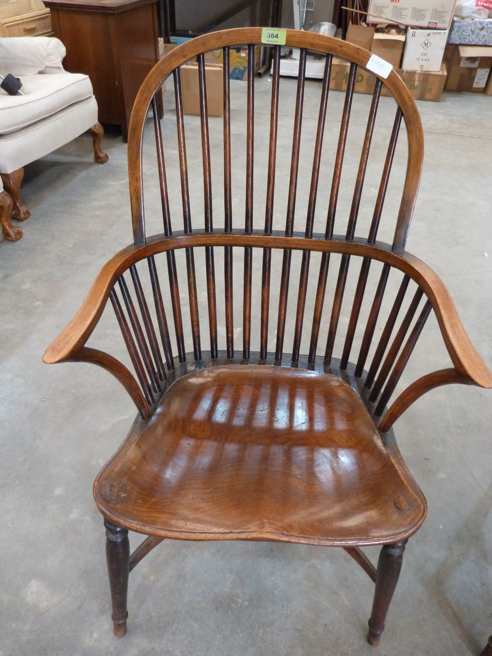An early 19th century ash and elm Windsor elbow chair on splayed legs with crinoline stretcher