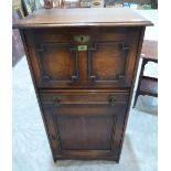 A 1920s oak cabinet with fall front over drawer and panel door. 21' wide