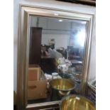 A wall mirror with silvered frame and bevelled plate. 43' x 31'