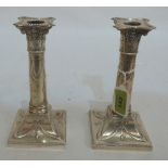 A pair of Edward VII silver candlesticks, of neo-classical form and repousse decorated with ribbon-