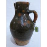 A post mediaeval type earthenware pitcher glazed in shades of predominantly green and ochre. 13'