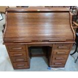 A 1930s oak roll-top desk enclosed by a tambour shutter. 48' wide