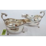 A pair of Elizabeth II silver helmet sauce boats with gadrooned rims and double scroll handles.