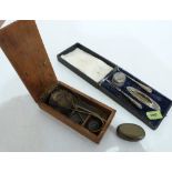 A miners brass tobacco box, a cased silver manicure set and a boxed set of scales