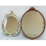 A Sitzendorf porcelain strut mirror, the frame with putto surmount and applied flowers, 12' high (