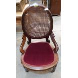 A Victorian walnut tub chair with oval caned back