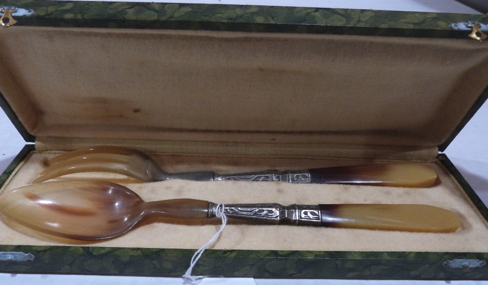 A cased horn and white metal mounted serving spoon and fork