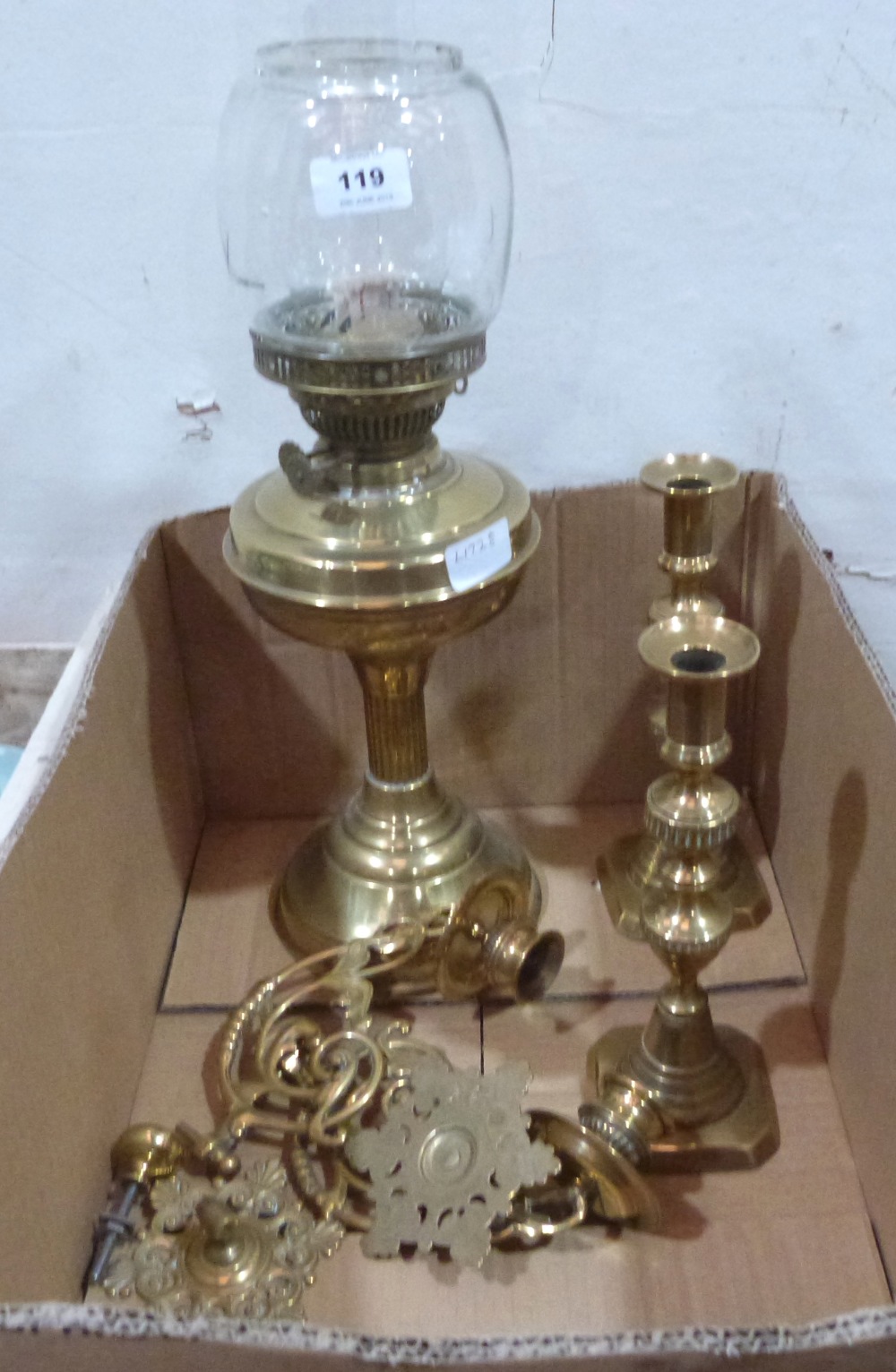 A brass oillamp, a pair of brass piano sconces and a pair of brass candlesticks