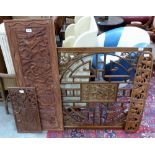 An oriental carved and pierced wood panel and three ethnic wood carvings