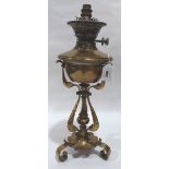 A Victorian brass oillamp on scrolled wrought tripartite support. Converted for electricity 17½'