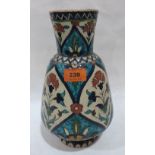 A Persian 'Iznik' vase, blue glazed and painted with flowers. 11½' high. Repairs