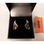 A pair of 9ct earrings set with pear shaped peridots and diamonds.