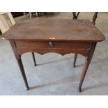 An early 18th century oak side table with frieze drawer over shaped apron, on turned tapered legs