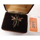 An Edwardian gold dragonfly brooch, the thorax set with six graduated green stones, the wings and