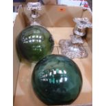 A pair of plated candlesticks, two green glass witch's balls and an eastern bell