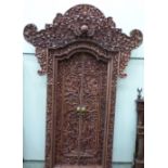 A fine and magnificent Balinese doorway, profusely carved all over with figures, foliage,