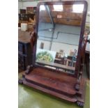 A Victorian mahogany dressing table mirror, the rectilinear swing plate on volute carved