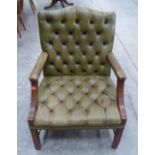 A George III style elbow chair upholstered in deep buttoned green leather. Early 20th century