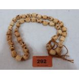 A necklace of carved bone skulls beads