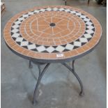 A metal garden table with tiled top