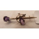 A white metal fly bar brooch set with two amethysts