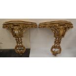 A pair of carved wood recoco revival parcel gilt console tables with inlet marble tops. (One cracked