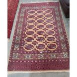 A Pakistani red and beige ground rug. 76' x 48'