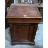 A William IV rosewood davenport, the sliding top with sloping fall and pen drawer, over four real