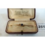 A 9ct bar brooch set with a sapphire and two split pearls to the knife wire. 2.4g gross