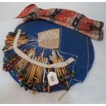 A lacemaker's work cushion with a collection of 49 bobbins and part completed lacework