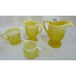 Four Victorian pressed vaseline glass jugs, the larger example 5' high