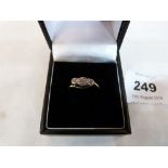 A three diamond cross-over ring. In gold marked 18. 1.9g gross. Size O