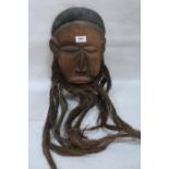 A carved wood Zambian mask with cow hair beard. 12' high