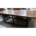 A joined oak refectory table, the cleated plank top on turned gun barrel and wrythen supports with