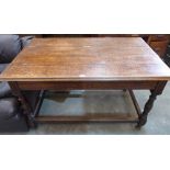 A Victorian oak table, the moulded hinged top revealing a well, raised on turned baluster legs