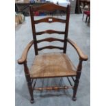 A 19th century ladderback elbow chair with rush seat. Repairs