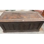 An antique oak chest of unusually large proportion with carved four panel front, the interior with a