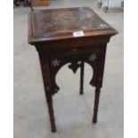 An Islamic carved hardwood occasional table with mother-of-pearl inlay